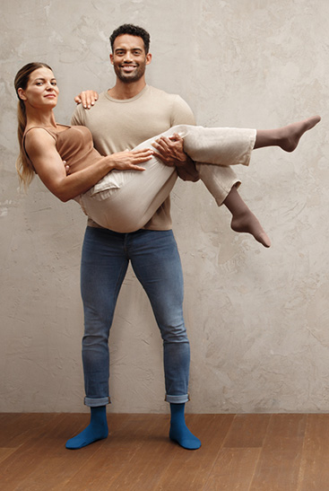 2. Juzo Intenso Uomo con donna in braccio, entrambi indossano le calze Juzo Intenso