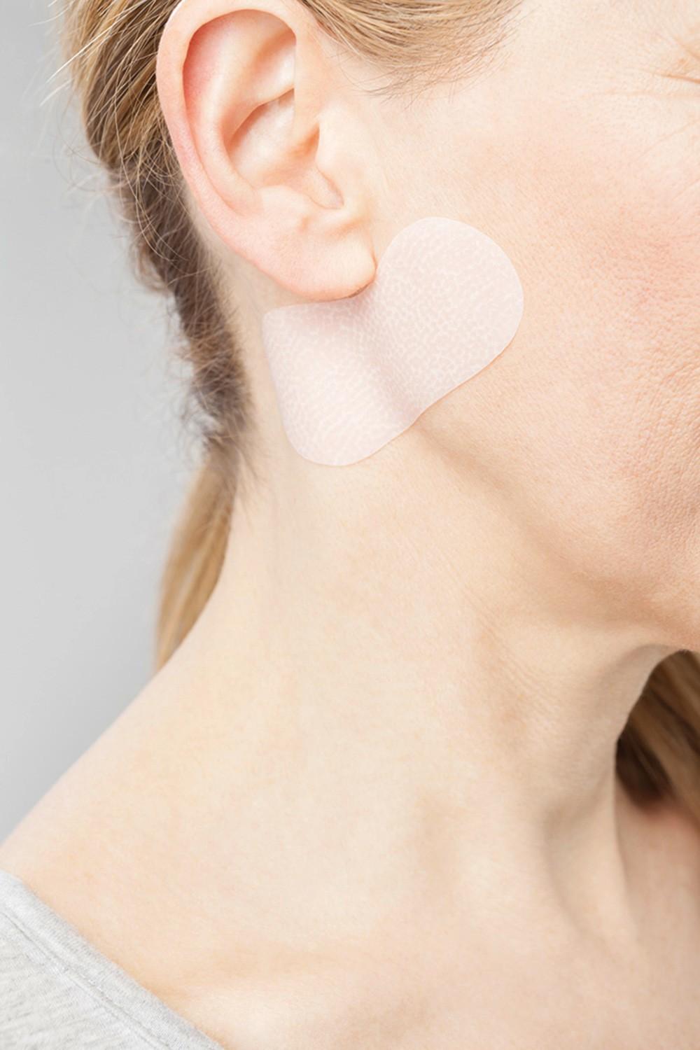 Kvinna använder Juzo ScarPad på halsen