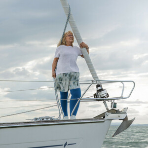 Eine Frau steht auf einem Boot, sie trägt eine Kompressionsstrumpfhose