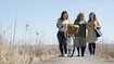 Three women on a footbridge. They are wearing compression garments.