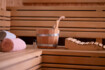 Man erkennt eine Sauna aus Holz mit Handtüchern, einem Topf und einer Kopflehne