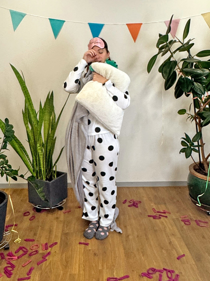 Schlafanzug Eine Frau trägt einen Schlafanzug, Kissen, Decke, eine Schlafmaske und ein Plüschtier als Kostüm für Fasching.