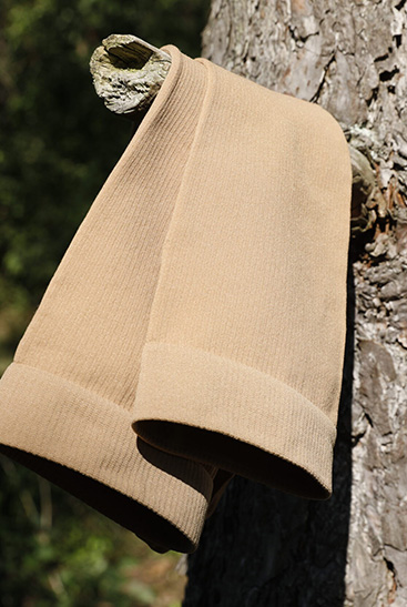 8. Lifestyle Bild Juzo Adventure Juzo Adventure Strumpf in Sesam hängt über einem Ast