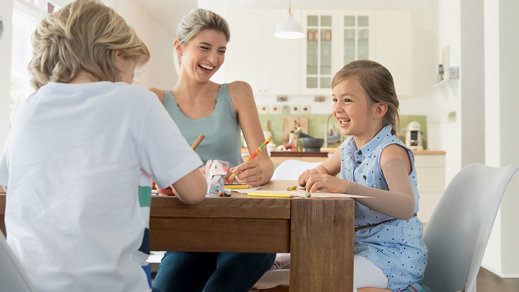 Familie sitzt am Tisch beim Malen Familie sitzt am Tisch beim Malen